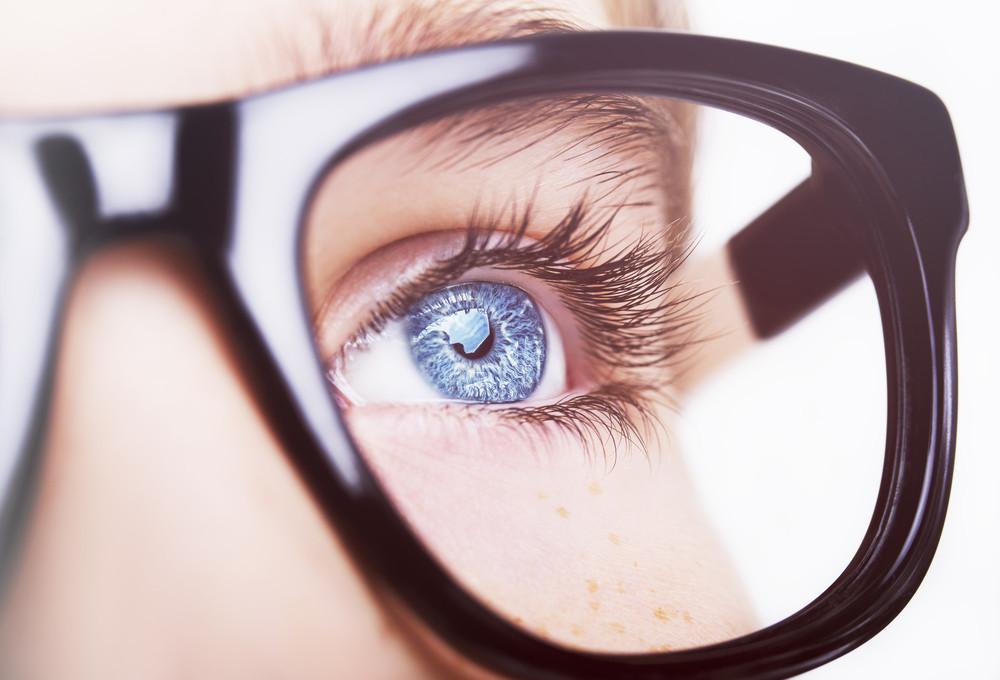 крупный план голубого глаза девушки в очках